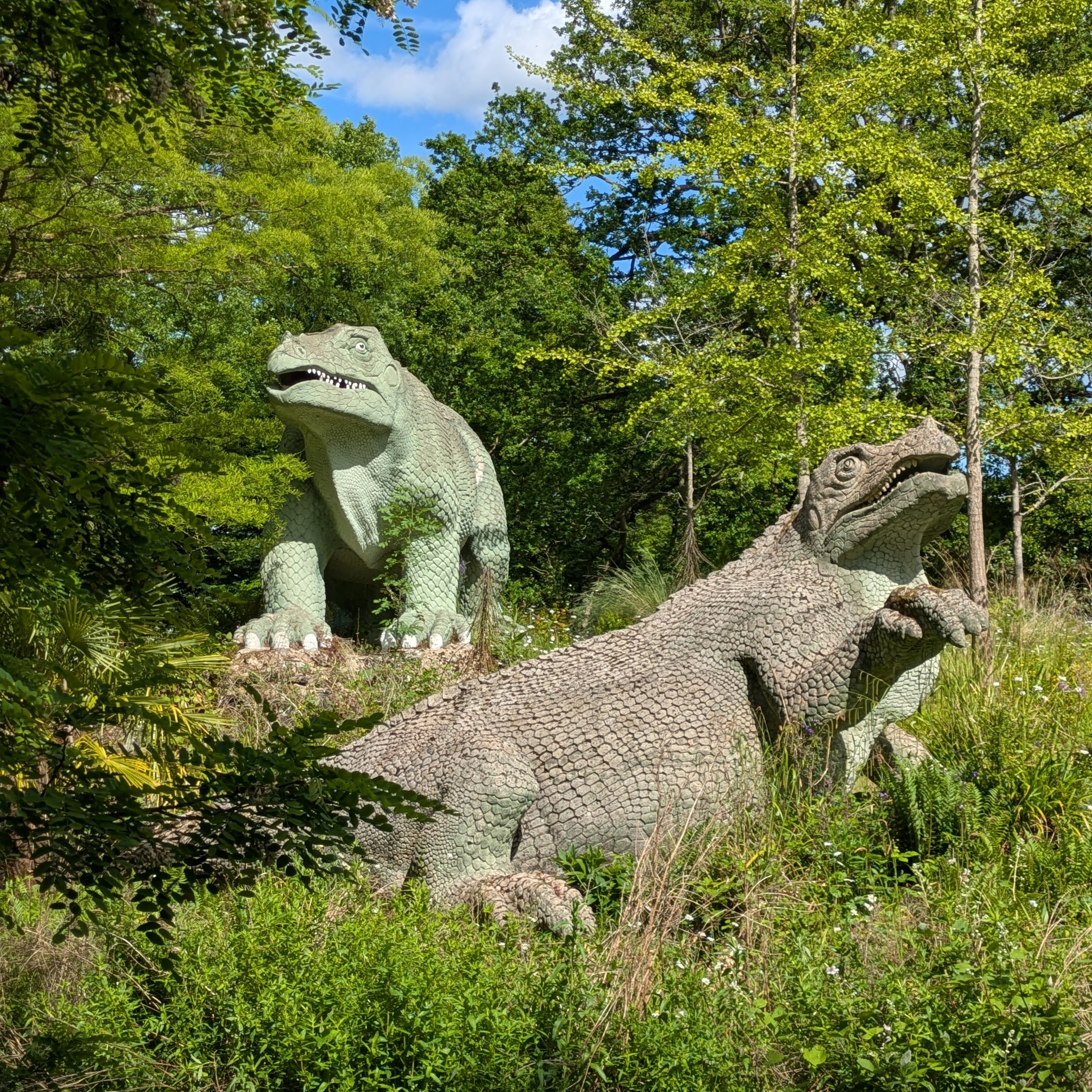 two of the Victorian-era life-size 
           	model dinosaurs at Crystal Palace Park in south London, in the sun