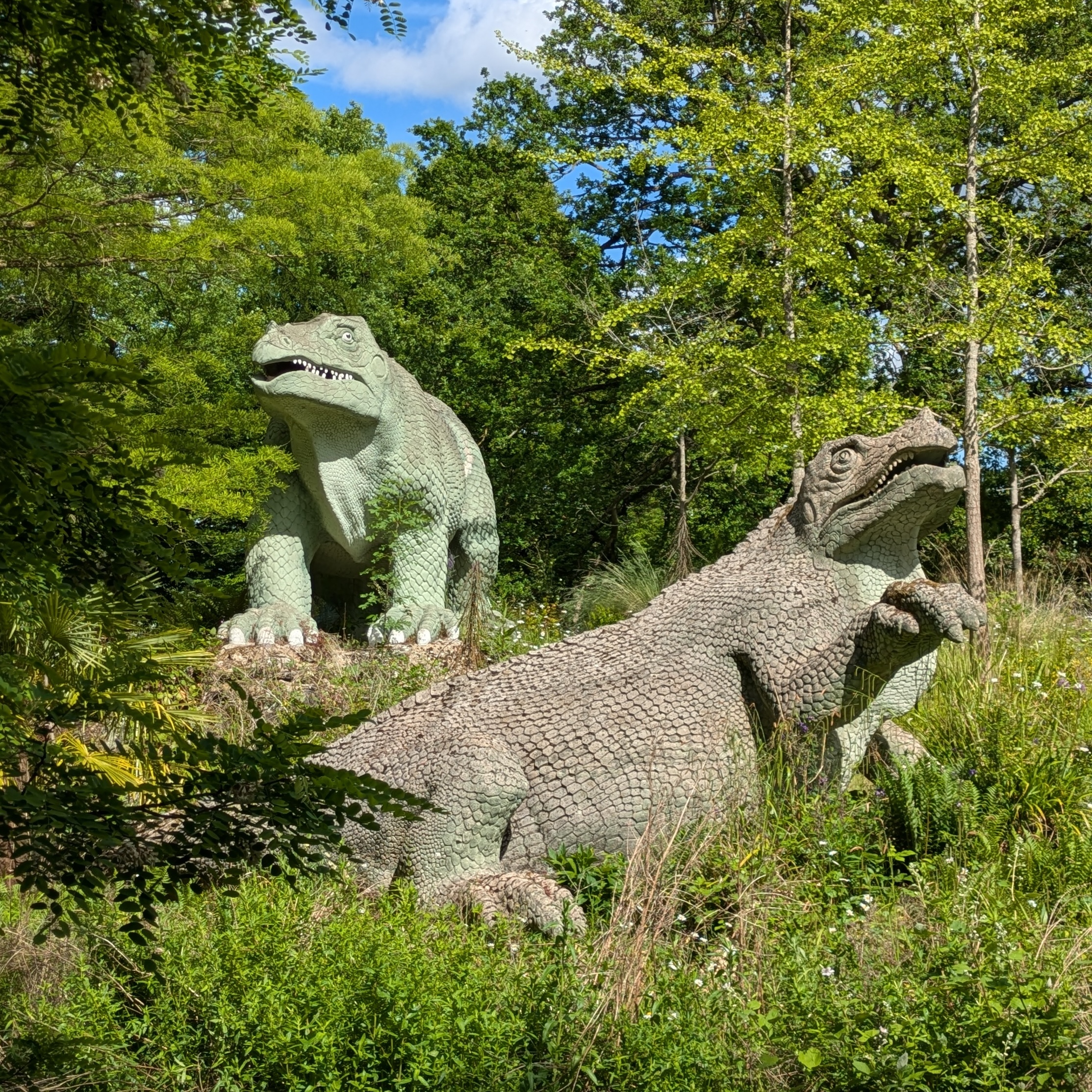 two of the Victorian-era model
           	dinosaurs, at Crystal Palace Park in south London, in the sun